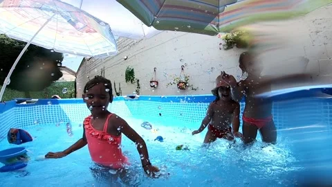Children splashing and playing in a backyard swimming pool Stock Footage 316337741