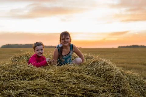 Children on a stack of straw Stock Photos