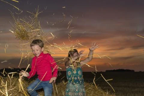Children on a stack of straw Stock Photos