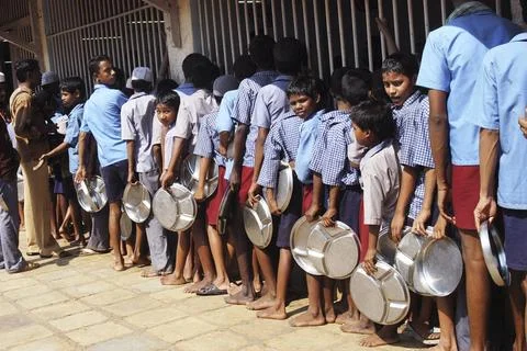 Children standing in queue with round molded stainless steel plate for lun... Stock Photos