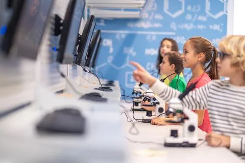 Children standing sideways to camera looking at charge boards Stock Photos