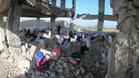 Children study inside a school destroyed by war in Yemen, Taiz Stock Footage 160208655