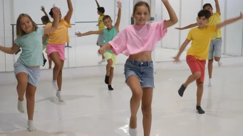 Children studying modern style dances in dance class indoors Stock Footage 164703611