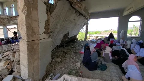 Children studying in a school destroyed by the war Stock Footage 160576790
