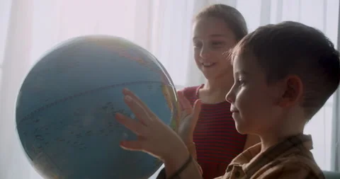 Children is studying while sitting at home in rays sunset in room.Kids in Stock Footage 235862795