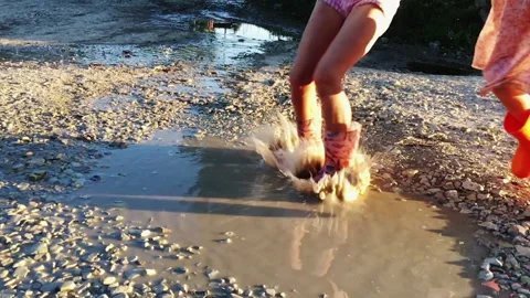 Children, summer, puddle, joy. Slow moment of jump in water Stock Footage 202721276