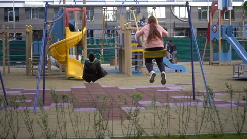 Children swing on a swing in slow motion Stock Footage 130557552
