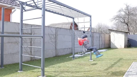 Children swinging on a swing in a backyard Stock Footage 150480443