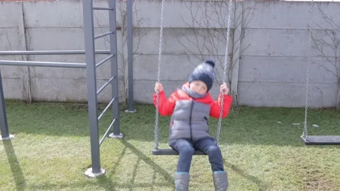 Children swinging on a swing in a backyard Stock Footage 150480475