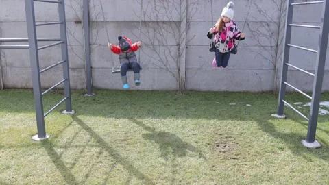 Children swinging on a swing in a backyard Stock Footage 150480491