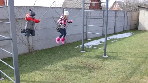 Children swinging on a swing in a backyard Stock Footage 150480540