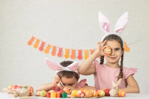 Children at the table decorated for Happy Easter. Girl and boy have fun getting Stock Photos