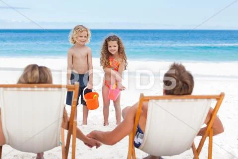 Children Talking With Their Parents On The Beach