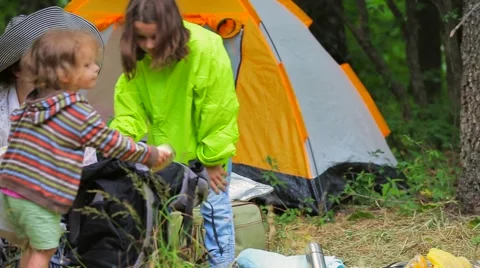 Children in the tent town sort a backpack, take out things and products Stock Footage 53494242
