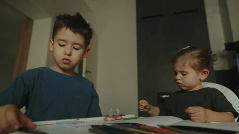 Children with their homework sitting on table, writing and drawing at home Stock Footage 251615555