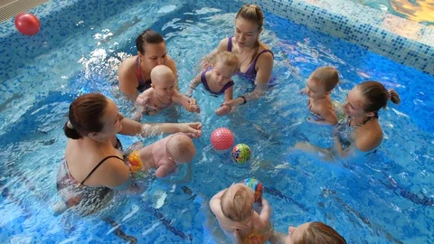 Children with their moms in the pool Stock Footage 125072396