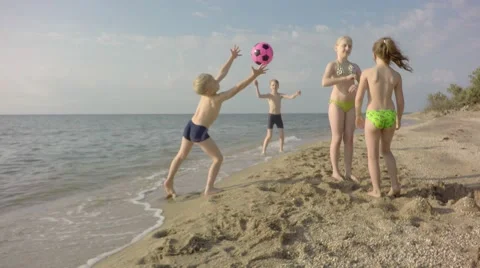 Children throw the ball in the sea. 库存影片 65243867