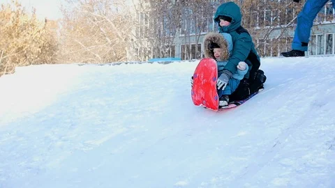 Children together rolling down a hill on a sled Video stock 69857213