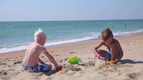 The children two cute boys play with a sand near sea Stock Footage 261182018