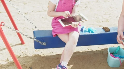Children use a computer tablet, walk on the playground Video stock 107956902