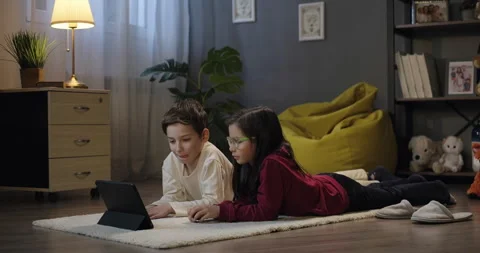 Children use digital tablet in the evening, watch educational video, streaming Stock Footage 275543380
