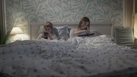 Children using digital devices in bed Stock Footage 165063760