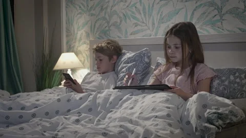 Children using digital devices in bed Stock Footage 165067240