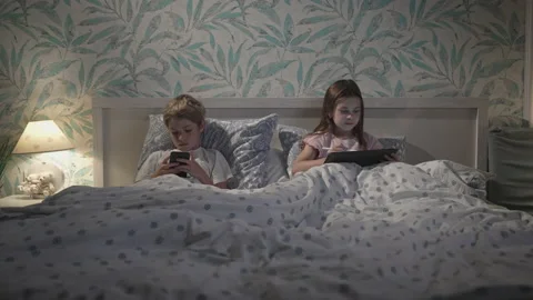 Children using digital devices in bed. Stock Footage 165620504