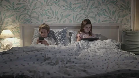 Children using digital devices in bed Stock Footage 165990867