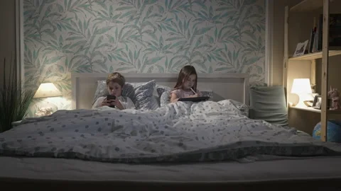 Children using digital devices in bed Stock Footage 166323893