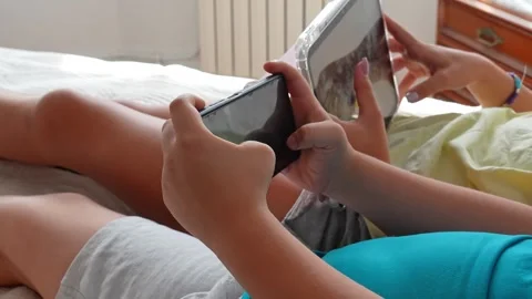 Children using digital tablet and smartphone lying on a bed Video stock 341599313