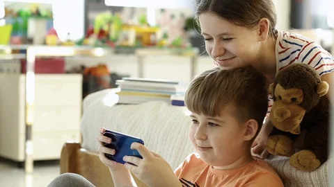  Children  using smart phone together browsing online. Stock Footage 128657779