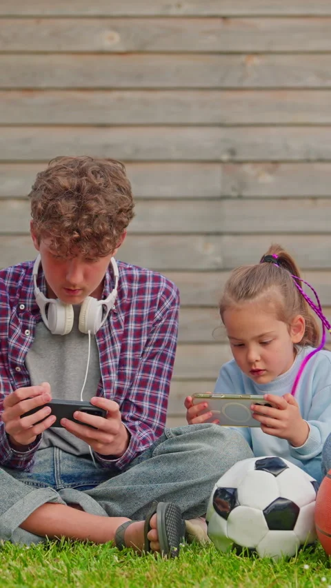 Children using smartphone together outdoor. Smartphone addiction Stock Footage 314658344
