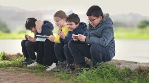Children using smartphones and tablets outdoors Stock Footage 327856276