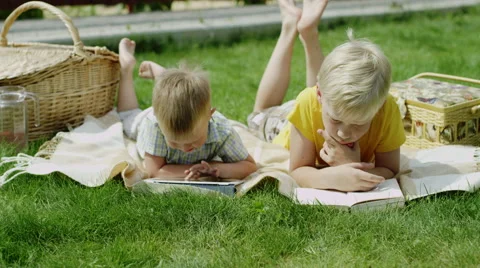 Children using tablet and reading a book Stock Footage 66061209