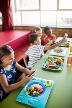 Children using technology during lunch Foto stock