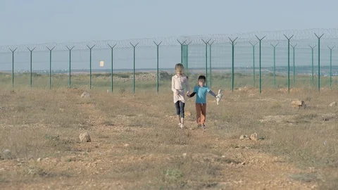 Children walk a dirt path circa in the refugee camp. concept Immigration crisis Stock Footage 102945632