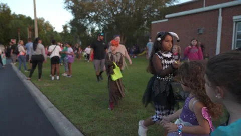 Children Walking with Buckets After Trunk-Or-Treat Stock Footage 318108783