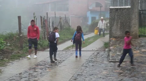 Children walking down a road in a misty, mountain fog in Latin America Stock Footage 63218502