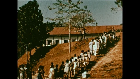 Children walking to school, having P.E. outside, on sunny day, 1959, Pakistan Stock Footage 130669918