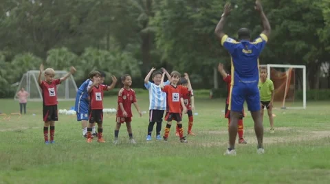 Children Warming Up With Their Coach In Park Before Playing Soccer Stock Footage
