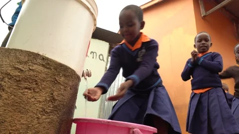 Children washing their hands before having a lunch in rural school in Africa Stock Footage 230078086