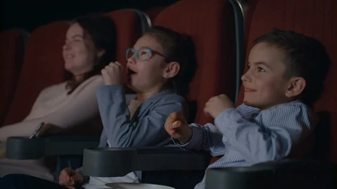 Children watching movie enthusiastically in cinema. Child entertainment concept Stock Footage 93966183