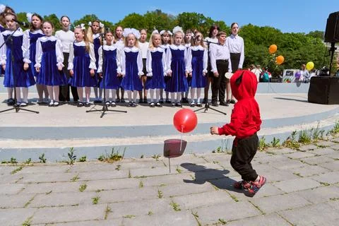 Children watching school choir performance outdoors Fotos de archivo