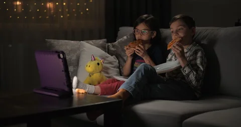 Children watching video on tablet on the sofa at home Stock Footage 247622095