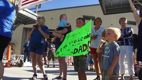 Children waving banner while waiting for airmen to arrive home from deployment Stock Footage 113394557