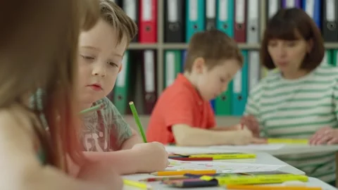 Children work in a lesson at school with a teacher. Stock Footage 248438908