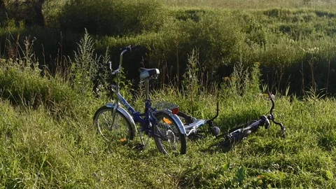 Children's bicycles in the grass by the river Stock Footage 104956803