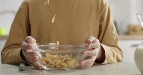 Children's breakfast. Corn flakes falling into kid's bowl. Cereal preparation in Stock Footage 269508647