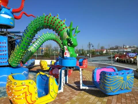 Children's carousel in the shape of a multi-headed dragon Stock Photos